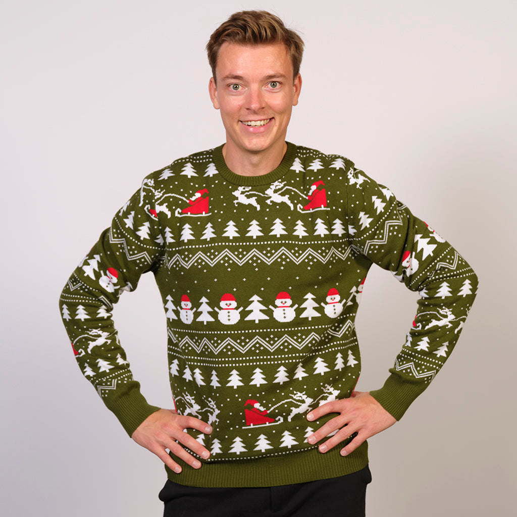 Un homme portant un pull vert de Noël avec des arbres de Noël, des pères Noël et un motif de Noël.